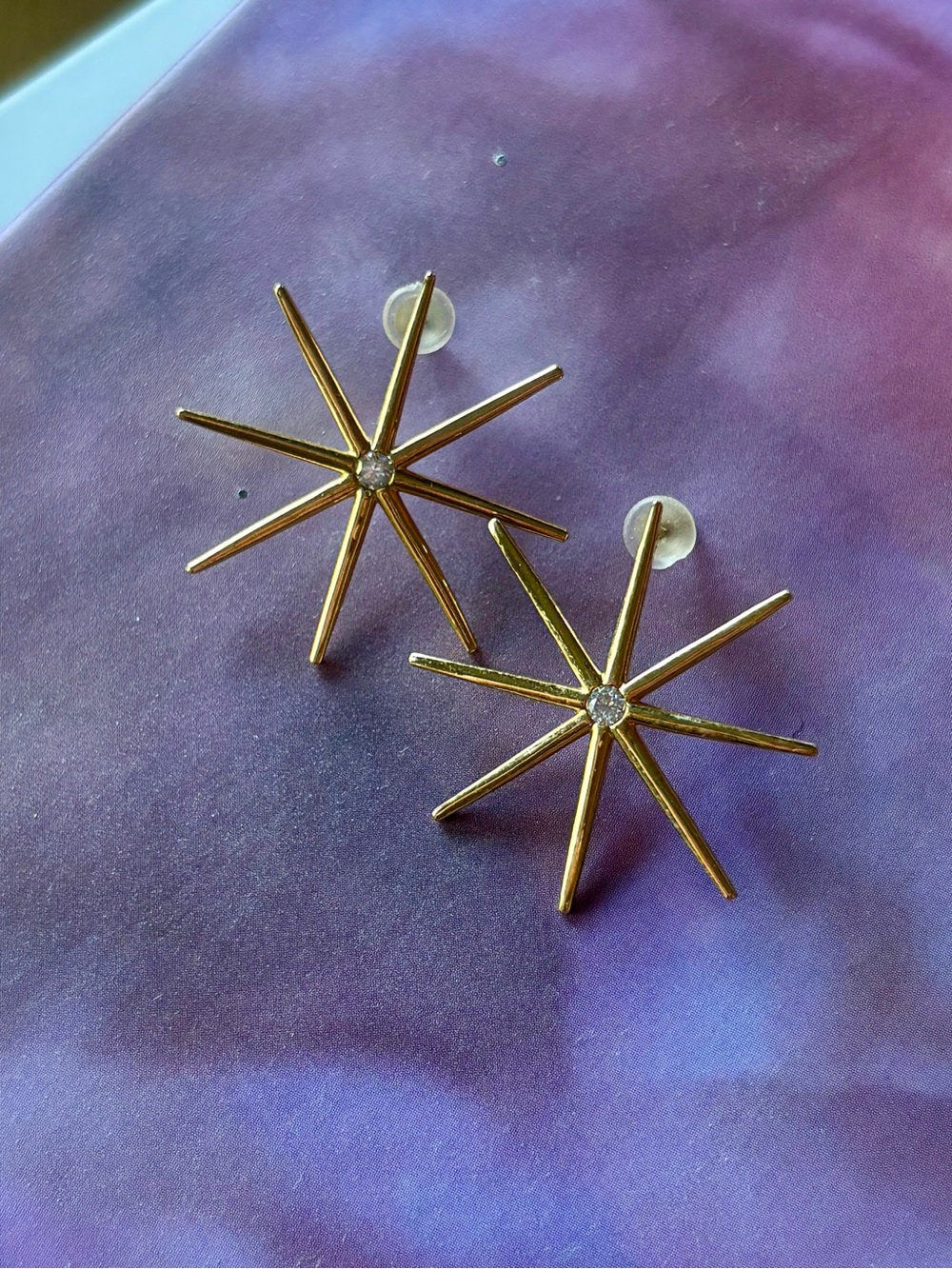 Gold starburst stud earrings with crystal accent